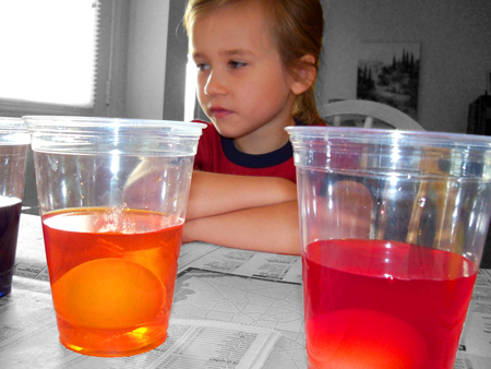 Corina helps dye eggs.